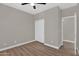 Neutral bedroom showcases wood-look floors, ceiling fan, closet, and an entrance to another room at 3376 E Lafayette Ave, Gilbert, AZ 85298