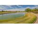 Beautiful golf course view with a tranquil pond and lush green grass under a sunny sky at 3376 E Lafayette Ave, Gilbert, AZ 85298