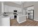 Bright kitchen features white cabinetry, stainless steel appliances, and a center island with quartz countertops at 3376 E Lafayette Ave, Gilbert, AZ 85298