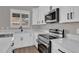Kitchen with white cabinets, black hardware, stainless steel appliances, quartz countertops and a large sink at 3376 E Lafayette Ave, Gilbert, AZ 85298
