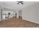 Open-concept living room seamlessly flows to kitchen, featuring wood floors, ceiling fan, and modern design at 3376 E Lafayette Ave, Gilbert, AZ 85298