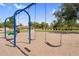 Swings at the community playground under blue skies with grassy areas in the background at 3376 E Lafayette Ave, Gilbert, AZ 85298