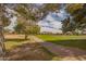Scenic view of a paved walking path on a golf course with mature trees and mountain views at 3376 E Lafayette Ave, Gilbert, AZ 85298