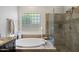 Spa-like bathroom with a deep soaking tub, separate shower with glass door, and elegant fixtures at 3766 E Ringtail Way, Phoenix, AZ 85050