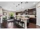 Spacious kitchen with dark wood cabinetry, a granite island with seating, and stainless steel appliances at 3766 E Ringtail Way, Phoenix, AZ 85050