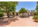 Expansive backyard with brick paving and lush trees providing shade and privacy at 38 E Calavar Rd, Phoenix, AZ 85022