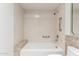 Clean bathroom with a tub, shower, tiled walls and safety grab bars at 38 E Calavar Rd, Phoenix, AZ 85022