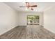Bedroom with a ceiling fan, wood-look floors, and sliding glass door providing natural light and access to outdoors at 38 E Calavar Rd, Phoenix, AZ 85022