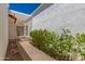 A close up of a property exterior with white wall, garden hedge, and a partial view of the barrel roof at 38 E Calavar Rd, Phoenix, AZ 85022