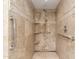 Walk-in shower featuring tiled walls, multiple shower heads, and safety bars, creating a spa-like experience at 38 E Calavar Rd, Phoenix, AZ 85022