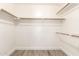 Spacious walk-in closet with wood-look floors and ample hanging storage for optimal organization at 38 E Calavar Rd, Phoenix, AZ 85022