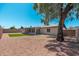 Spacious backyard with gravel, a patch of green grass, patio, and shaded by mature tree at 3910 W Kings Ave, Phoenix, AZ 85053