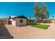 View of the backyard with patio, manicured lawn, desert landscaping, and mature shade tree at 3910 W Kings Ave, Phoenix, AZ 85053