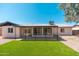 A covered patio extends from the house to the manicured green lawn at 3910 W Kings Ave, Phoenix, AZ 85053