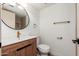 Modern bathroom with wood vanity, bronze fixtures, round mirror, and decorative hardware at 3910 W Kings Ave, Phoenix, AZ 85053