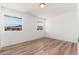 Bright bedroom featuring wood-look floors, white walls, and natural light from two windows at 3910 W Kings Ave, Phoenix, AZ 85053