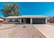View of the home's facade with mature landscaping and a single car garage at 3910 W Kings Ave, Phoenix, AZ 85053