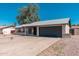 Exterior view of single-story home with black garage door and desert landscaping at 3910 W Kings Ave, Phoenix, AZ 85053