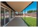 Inviting patio with cover, perfect for entertaining, leading to a grassy backyard at 3910 W Kings Ave, Phoenix, AZ 85053