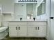 Bathroom featuring a dual sink vanity, white cabinets, quartz countertop, black fixtures, and modern lighting at 4050 E Agave Rd, Phoenix, AZ 85044