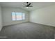 Bright bedroom featuring a vaulted ceiling, large window, neutral carpet, and a modern ceiling fan with light at 4050 E Agave Rd, Phoenix, AZ 85044