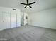 Spacious bedroom with neutral carpet, white walls, closet with sliding doors, and ceiling fan with light at 4050 E Agave Rd, Phoenix, AZ 85044
