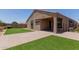 A nice view of the backyard with a brick patio and turf at 41041 W Somers Dr, Maricopa, AZ 85138
