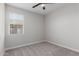 A light and bright bedroom with carpeted floor, white walls and trim, and a ceiling fan with a light at 41041 W Somers Dr, Maricopa, AZ 85138