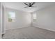 Bedroom featuring neutral carpet, two windows for ample natural light, and a ceiling fan at 41041 W Somers Dr, Maricopa, AZ 85138