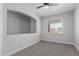 Bedroom featuring neutral carpet, a ceiling fan, and large windows for natural light at 41041 W Somers Dr, Maricopa, AZ 85138