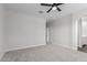 Spacious bedroom featuring neutral carpet, a ceiling fan, and two windows for ample light at 41041 W Somers Dr, Maricopa, AZ 85138