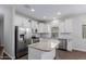 Kitchen features stainless steel appliances, granite countertops, and white cabinetry, offering a blend of style and functionality at 41041 W Somers Dr, Maricopa, AZ 85138