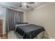 Bedroom with a comfortable bed, dark bedding, gray curtains, and wood flooring at 450 N 110Th St, Mesa, AZ 85207