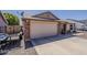 A home's two-car garage and brick pillar entryway are showcased with the long concrete driveway at 450 N 110Th St, Mesa, AZ 85207