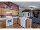 Open kitchen with ample counter space, wooden cabinets and an easy serving bar to the living room at 450 N 110Th St, Mesa, AZ 85207