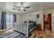 The main bedroom features wood floors, a ceiling fan, and access to a view through a sunlit window at 450 N 110Th St, Mesa, AZ 85207