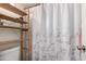 Functional bathroom featuring a shower with patterned curtain and shelving for storage at 461 W Holmes Ave # 350, Mesa, AZ 85210