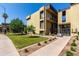Exterior view of a multi-story apartment building with well-manicured lawn and sidewalks on a bright, sunny day at 461 W Holmes Ave # 350, Mesa, AZ 85210