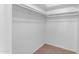 A closet with white walls and carpet flooring, featuring white rods for hanging clothes at 527 N Lesueur --, Mesa, AZ 85203
