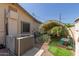 Backyard with an AC unit, a garden area with climbing plants, and artificial grass at 538 E Estevan Ave, Apache Junction, AZ 85119