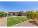 Landscaped backyard featuring artificial turf, decorative gravel, and desert plants at 538 E Estevan Ave, Apache Junction, AZ 85119
