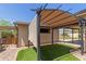 Cozy backyard space with a covered pergola, artificial turf, and gravel landscape at 538 E Estevan Ave, Apache Junction, AZ 85119