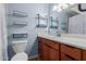 Well-lit bathroom featuring a single sink vanity, open shelving, and a classic marble shower curtain at 538 E Estevan Ave, Apache Junction, AZ 85119