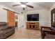 Open-concept living room with tile flooring, TV, a wooden entertainment center, and access to other rooms at 538 E Estevan Ave, Apache Junction, AZ 85119