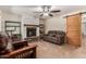 Cozy living room with a brick fireplace, stylish ceiling fan, tile floors, and comfortable brown leather sofas at 538 E Estevan Ave, Apache Junction, AZ 85119
