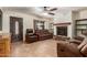 Inviting living room with a stone fireplace, modern ceiling fan, tile floors, and comfortable seating at 538 E Estevan Ave, Apache Junction, AZ 85119