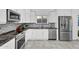 Modern kitchen featuring stainless steel appliances, granite countertops, mosaic tile backsplash, and ample cabinet space at 6201 E Waltann Ln, Scottsdale, AZ 85254