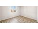 A bright, empty bedroom featuring wood-look flooring and a window offering natural light at 7661 W Meadowlark Way, Florence, AZ 85132