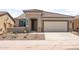 Charming single-story home with a well-manicured front yard, desert landscaping, and a two-car garage at 7661 W Meadowlark Way, Florence, AZ 85132