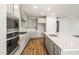 Bright, open kitchen featuring white cabinets, stainless appliances, and a large center island at 7661 W Meadowlark Way, Florence, AZ 85132